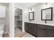 Bright bathroom featuring dual sinks, black framed mirrors and walk-in closet with shelving at 741 Rockville Rd, Wake Forest, NC 27587