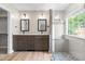 Modern bathroom features dual vanity, walk-in shower with decorative tile, and plenty of natural light at 741 Rockville Rd, Wake Forest, NC 27587