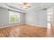 Large bedroom with hardwood floors, ceiling fan, tray ceiling, and a large window at 741 Rockville Rd, Wake Forest, NC 27587