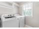 Functional laundry room with washer, dryer, shelving, and a window at 741 Rockville Rd, Wake Forest, NC 27587
