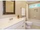 Bathroom with neutral color walls, white vanity, decorative mirror and shower-tub combo at 8504 Carlton Oaks Dr, Wake Forest, NC 27587