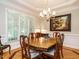 Well-lit dining room with a wooden table, chandelier, and large windows at 8504 Carlton Oaks Dr, Wake Forest, NC 27587