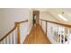Upstairs hallway with hardwood floors and white railing at 8504 Carlton Oaks Dr, Wake Forest, NC 27587