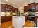 Beautiful kitchen featuring cherry cabinets, granite countertops, stainless steel appliances, and a white kitchen island at 8504 Carlton Oaks Dr, Wake Forest, NC 27587