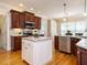 Bright kitchen featuring cherry cabinets, granite countertops, stainless steel appliances, and a white kitchen island at 8504 Carlton Oaks Dr, Wake Forest, NC 27587