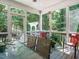 Screened-in porch with comfortable seating and view of the wooded backyard and pergola at 8504 Carlton Oaks Dr, Wake Forest, NC 27587