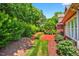 Lush backyard featuring a brick patio, manicured lawn, and plenty of mature trees at 8851 Mariner Dr, Raleigh, NC 27615