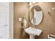 Elegant powder room featuring a pedestal sink and oval mirror at 8851 Mariner Dr, Raleigh, NC 27615