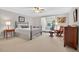 Well-lit bedroom featuring plush carpeting, ceiling fan, sitting area, and a full-sized bed at 8851 Mariner Dr, Raleigh, NC 27615