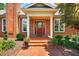 Charming brick home featuring a red front door with decorative glass and a brick walkway lined with flowers at 8851 Mariner Dr, Raleigh, NC 27615