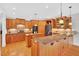 Kitchen with wood cabinets, granite countertops, island, breakfast bar, and hardwood floors at 8851 Mariner Dr, Raleigh, NC 27615