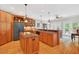 Kitchen with island, wood cabinets, granite countertops, stainless steel appliances, and hardwood floors at 8851 Mariner Dr, Raleigh, NC 27615