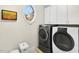This laundry room features modern washer and dryer units, a window, and white storage cabinets at 8851 Mariner Dr, Raleigh, NC 27615