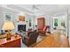 Bright living room featuring a fireplace, hardwood floors, and access to sunroom and backyard at 8851 Mariner Dr, Raleigh, NC 27615
