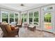 Bright sunroom featuring tile floors, white trim, and multiple windows overlooking the lush backyard at 8851 Mariner Dr, Raleigh, NC 27615