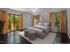 This virtually staged bedroom features dark floors and sunlit windows with cheerful orange curtains at 9709 Greenfield Rd, Chapel Hill, NC 27516