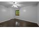 Simple bedroom with hardwood floors, a ceiling fan, and a view of the surrounding trees at 9709 Greenfield Rd, Chapel Hill, NC 27516