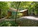 Charming home exterior with a screened-in porch, greenhouse, and lush landscaping surrounded by trees at 9709 Greenfield Rd, Chapel Hill, NC 27516