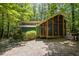 Exterior view of a charming home with a screened-in porch, surrounded by lush greenery and trees at 9709 Greenfield Rd, Chapel Hill, NC 27516