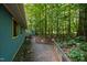 Exterior side view of a house with siding, surrounded by trees and greenery, showcasing its natural setting at 9709 Greenfield Rd, Chapel Hill, NC 27516