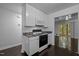 Bright kitchen with white cabinets, stainless appliances, dark wood floors, open to sunny living space at 9709 Greenfield Rd, Chapel Hill, NC 27516