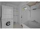 Functional laundry room with washer, dryer, utility sink, and built-in wire shelves for efficient organization at 9709 Greenfield Rd, Chapel Hill, NC 27516