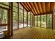Inviting screened porch with wood floors and a wood ceiling, surrounded by lush greenery at 9709 Greenfield Rd, Chapel Hill, NC 27516
