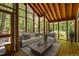 Virtually staged screened porch with wood floors, wood ceilings, and comfortable seating at 9709 Greenfield Rd, Chapel Hill, NC 27516