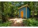 Outdoor shed surrounded by lush ferns and greenery, blending into the wooded landscape at 9709 Greenfield Rd, Chapel Hill, NC 27516