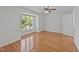 Light-filled bedroom with hardwood floors, ceiling fan, and a large window overlooking a lush yard at 1010 Nicholwood Dr # 301, Raleigh, NC 27605