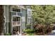 Exterior view of a multi-story apartment complex with balconies surrounded by lush trees at 1010 Nicholwood Dr # 301, Raleigh, NC 27605