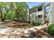 Exterior view of multi-story condo building surrounded by mature trees and landscaped grounds at 1010 Nicholwood Dr # 301, Raleigh, NC 27605