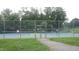Tennis courts with players engaged in a match, surrounded by a tall fence and greenery at 1010 Nicholwood Dr # 301, Raleigh, NC 27605