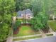 Aerial view of a spacious brick home nestled among mature trees, showcasing its landscaped yard at 105 Bathgate Ln, Cary, NC 27513