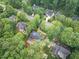 An aerial view showcases a home with a pool nestled among lush trees in a well-maintained neighborhood at 105 Bathgate Ln, Cary, NC 27513