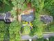 An aerial view of a luxurious home featuring a pool, lush landscaping, and surrounded by mature trees at 105 Bathgate Ln, Cary, NC 27513
