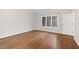 Sunlit bedroom with beautiful hardwood floors, a large window, and a white door at 105 Bathgate Ln, Cary, NC 27513