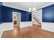 Bright dining room with hardwood floors, blue accent wall, and staircase view at 105 Bathgate Ln, Cary, NC 27513