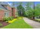Brick home's driveway with lush landscaping and mature trees, leading to a private setting at 105 Bathgate Ln, Cary, NC 27513