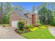 Brick home featuring an attached garage, lush landscaping, and well-maintained lawn at 105 Bathgate Ln, Cary, NC 27513