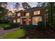 Elegant two-story brick home featuring a columned porch and bay window at twilight at 105 Bathgate Ln, Cary, NC 27513