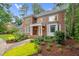 Charming two-story brick home with a welcoming porch, lush landscaping, and mature trees at 105 Bathgate Ln, Cary, NC 27513