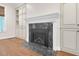 Close up of the fireplace with marble detail, built-in shelving, and hardwood floors at 105 Bathgate Ln, Cary, NC 27513