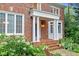 Charming brick home featuring a classic entrance with white columns and lush landscaping at 105 Bathgate Ln, Cary, NC 27513
