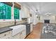 Open kitchen with eat-in island includes a stainless steel dishwasher, farm sink, and view of the Gathering room at 105 Bathgate Ln, Cary, NC 27513