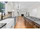 Bright kitchen with view to Gathering room features stainless steel appliances, farm sink, and granite countertops at 105 Bathgate Ln, Cary, NC 27513