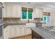 Bright kitchen features cream cabinets, stone backsplash, farmhouse sink, and stainless steel appliances at 105 Bathgate Ln, Cary, NC 27513