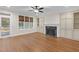 Living room with a fireplace, built-in shelving, hardwood floors, and natural lighting at 105 Bathgate Ln, Cary, NC 27513