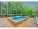 Outdoor built-in pool on a wooden deck, surrounded by a wooded landscape at 105 Bathgate Ln, Cary, NC 27513