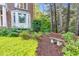 Landscaped yard featuring a stone bench among mature trees, ground cover, and shrubbery at 105 Bathgate Ln, Cary, NC 27513